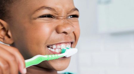 Child brushes teeth before dental clinic.