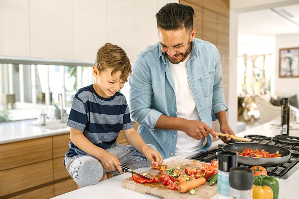 Father and child cutting veggies