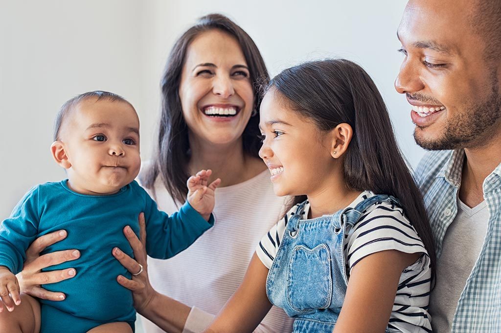 Family of four smiling.