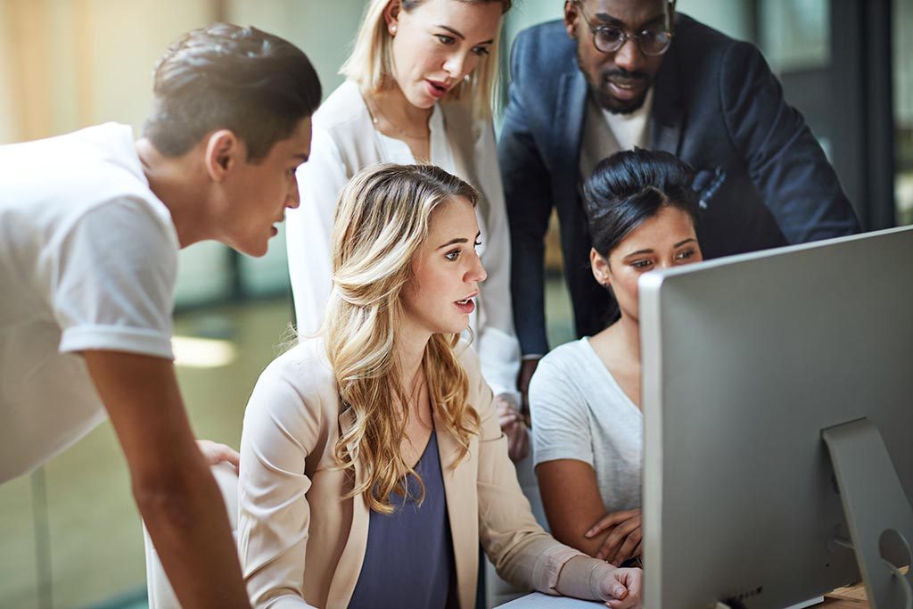 Group of young planners looking at computer