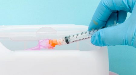 Used syringe placed in sharps container