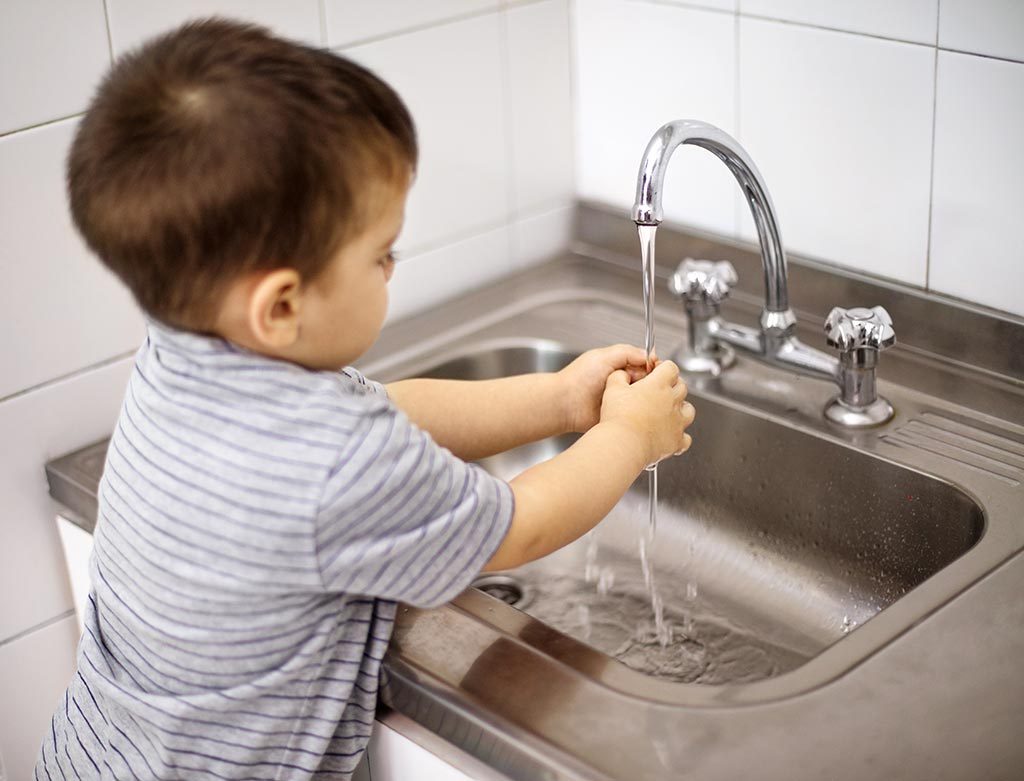 Toddler washing hands at daycare