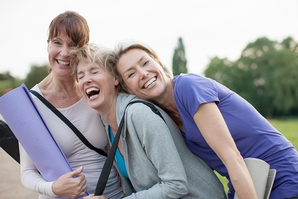 Three women laughing and smiling.