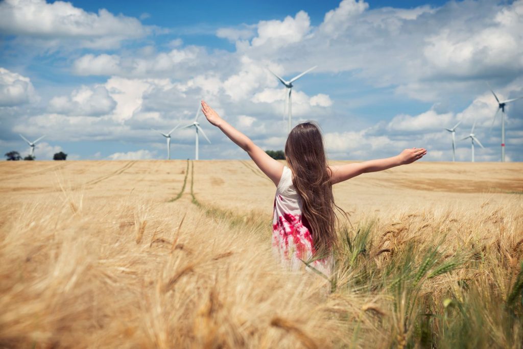 Young girl stands in a wheat field