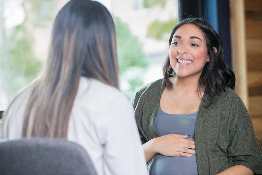 Pregnant woman in discussion with heath-care professional