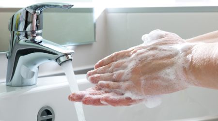 Washing hands in a bathroom sink.