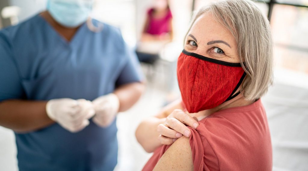 A women rolls up her sleeve to get a vaccine.