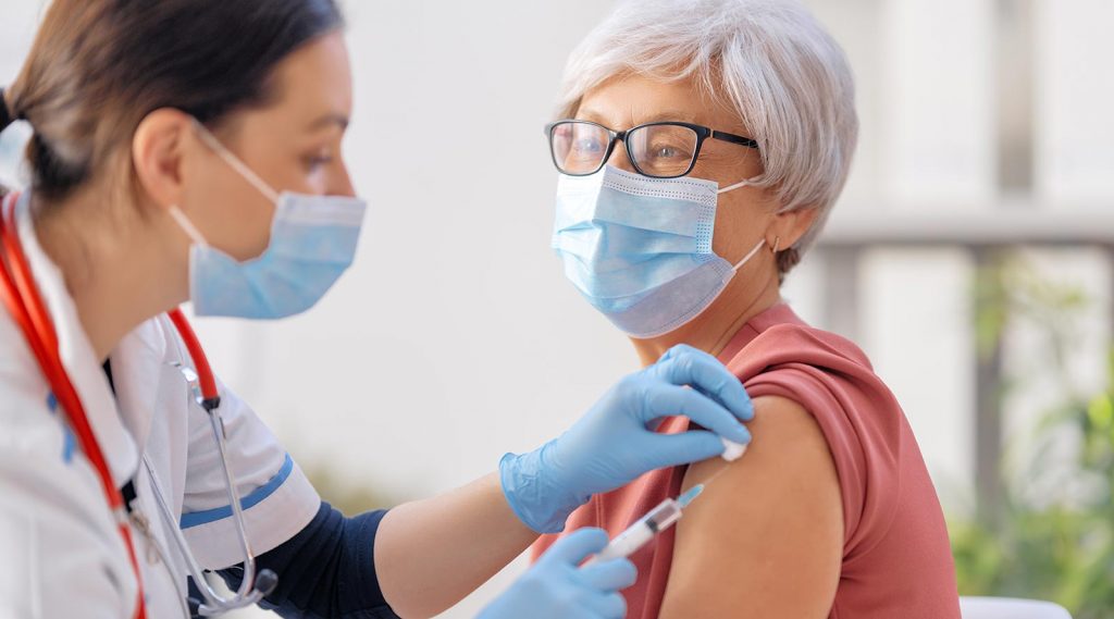 An elderly woman receives the COVID-19 vaccine.