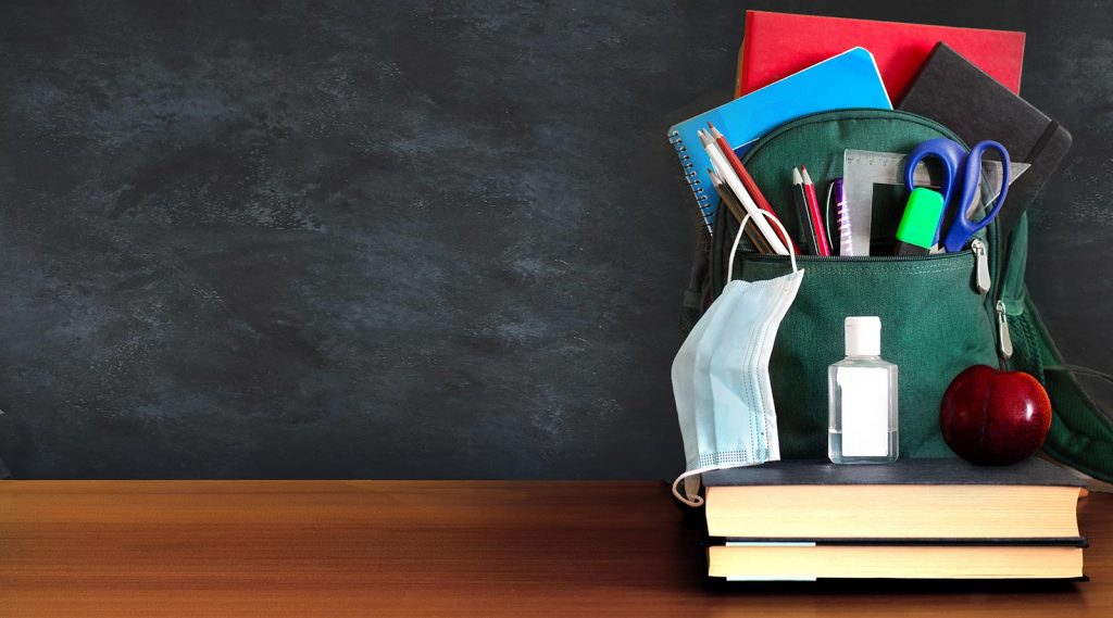 A backpack filled with school supplies, a mask and hand sanitizer.