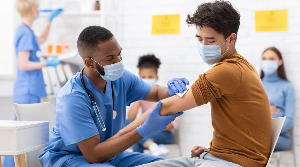 A young man receives a COVID-19 vaccination at a clinic.