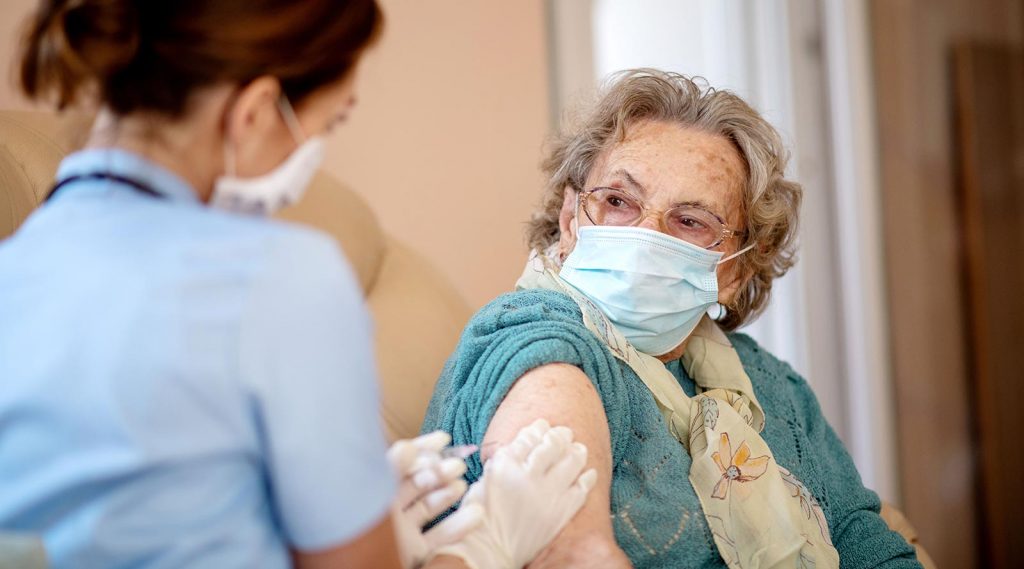 An elderly woman receiving the COVID-19 vaccine.