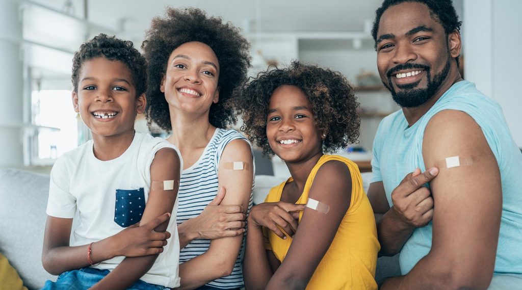 A family showing bandages from where they received the flu shot.