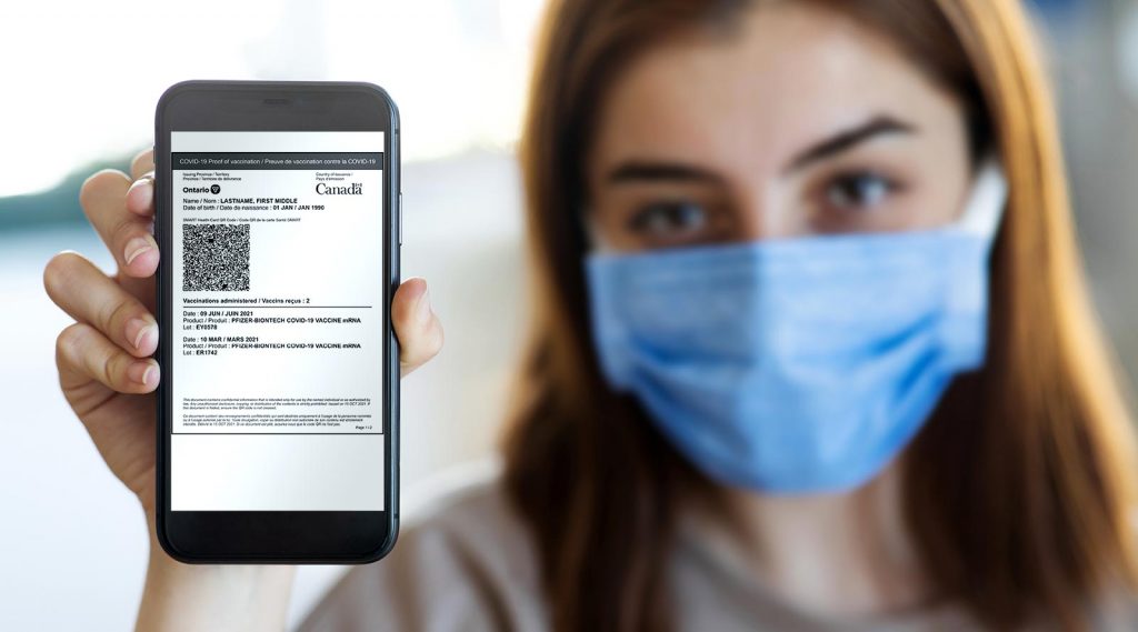 A young woman showing her proof of the COVID-19 vaccination.