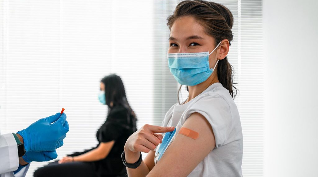 A teenaged girl receives a vaccination.