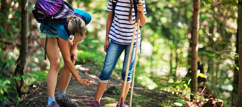 Mother applying tick repellant on daughter.