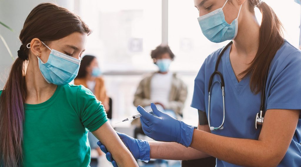 A nurse giving a child a covid-19 vaccine.