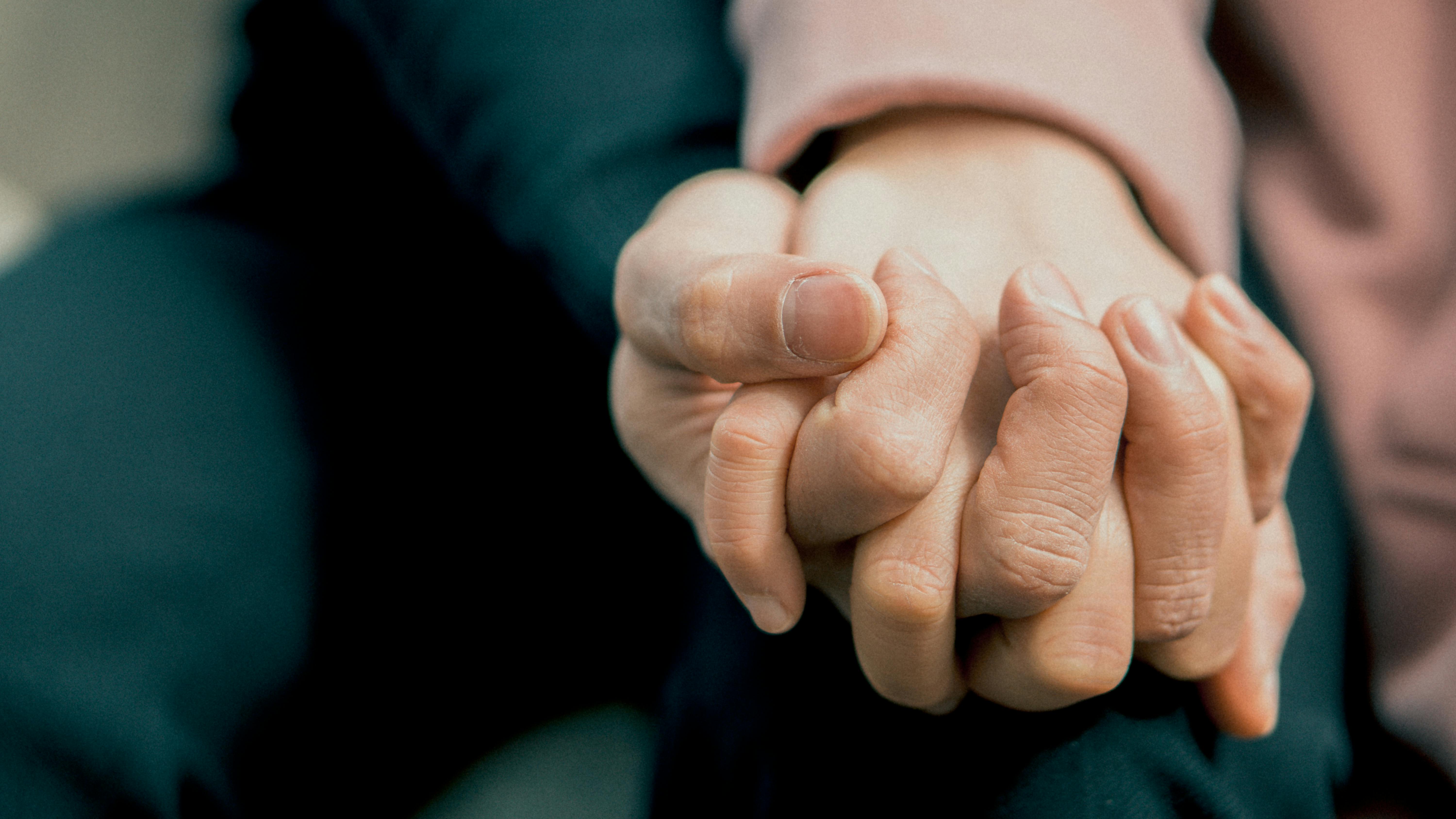 pexels-photo-1773113-1773113 A close-up photo capturing two adult hands holding each other, symbolizing love and support.